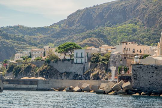 Seafront houses, a large tree and coastal defences in Lipari
