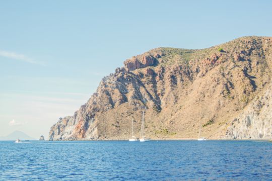 Tall coastal cliffs rising above the blue sea