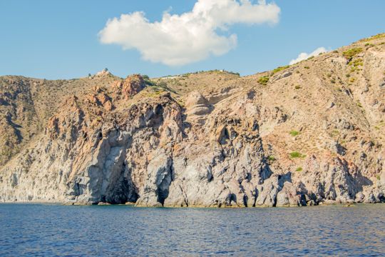 A rugged cliff face and sea caves viewed from the boat